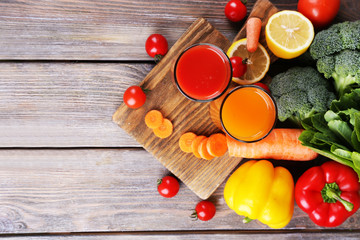Carrot and tomato juice in glasses and fresh vegetables