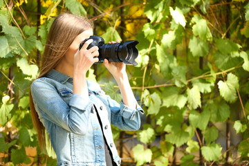 Beautiful young photography take photos outdoors in park