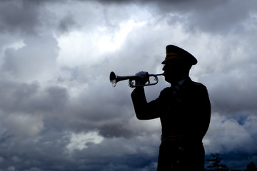 Silhouette of bugle player.