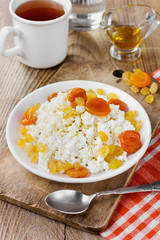 Curds with honey, raisin and dried apricots in a white plate