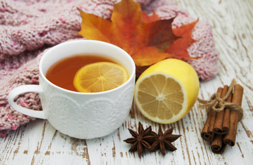 Cup of hot tea with lemon and scarf