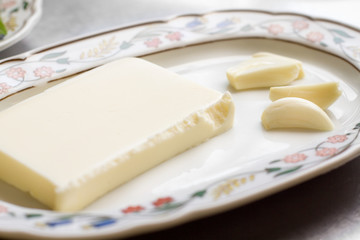 butter and clove of garlic over painted plate