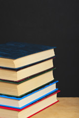 Pile of books on a wooden surface.