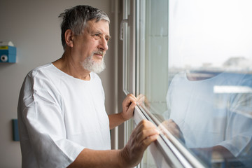 Patient at a hospital, looking from a window in his room