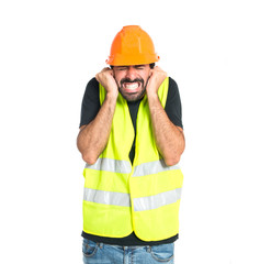 Workman covering his ears over white background