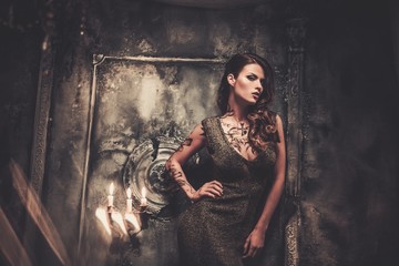 Tattooed beautiful woman in old spooky interior