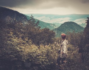 Fototapeta premium Woman with hiking equipment walking in mountain forest