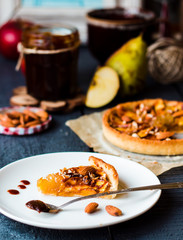 piece of apple tart on a round plate, spoon caramel