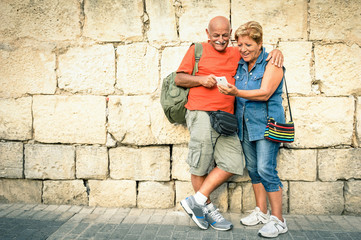 Happy senior couple having fun with a modern smartphone - obrazy, fototapety, plakaty