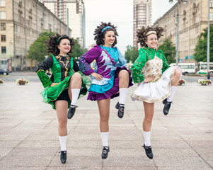 Three women in irish dance dresses dancing
