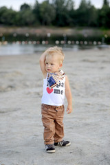 the kid is situated on the bank of the river on sand