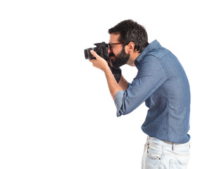 Young hipster man photographing over white background