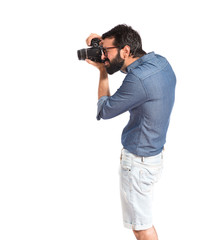 Young hipster man photographing over white background