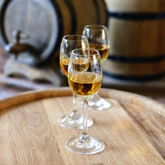 Glasses of wine in cellar with old barrels