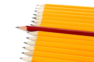 One red pencil standing out from others, isolated on white