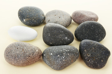 Obraz na płótnie Canvas Individuality concept. Sea stones on beige background