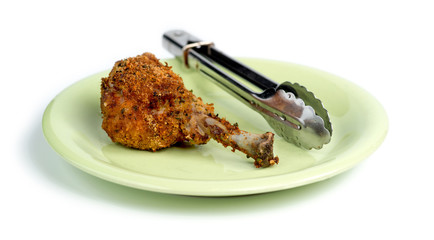 Breaded skinless fried chicken on green plate against white back