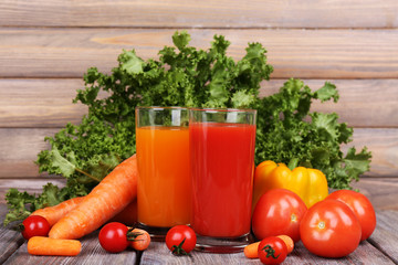 Carrot and tomato juice in glasses and fresh vegetables