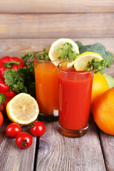 Carrot and tomato juice in glasses and fresh vegetables