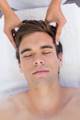 Fototapeta na wymiar Man receiving head massage at spa center