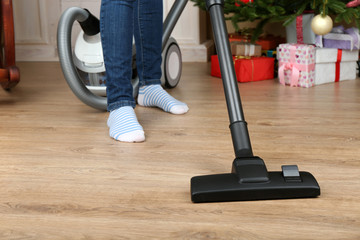 Woman with vacuum cleaner in room