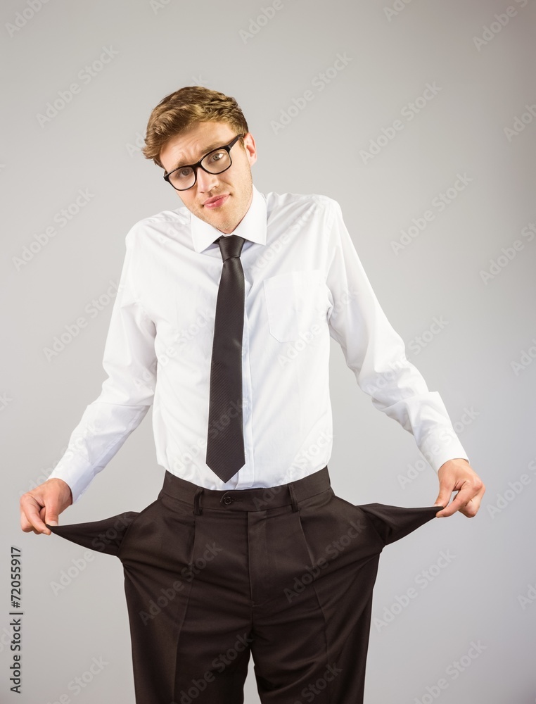 Poster geeky businessman showing his empty pockets