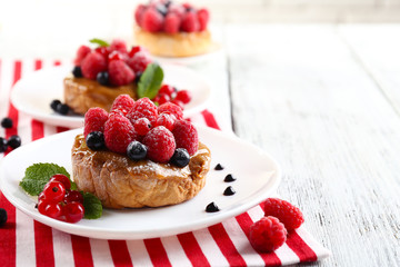 Sweet cakes with berries on table close-up