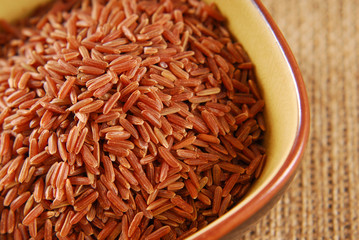 red rice in bowl on hessian fabric