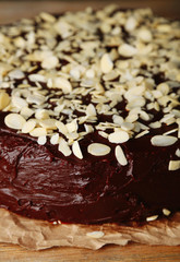 Tasty chocolate cake with almond, on wooden table