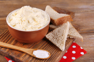 Fresh homemade butter in bowl and sliced bread,