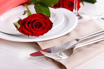Table setting with red rose on plate