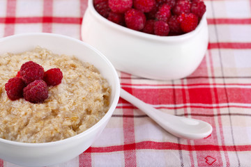 Tasty oatmeal with berries on napkin close-up