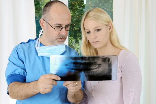 Zahnarzt bespricht Diagnose mittels Röntgenbild