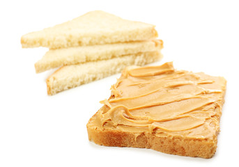 Creamy peanut butter and bread slices, isolated on white