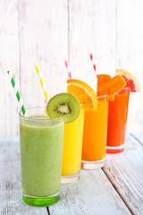 Fruit and vegetable juice in glasses and pieces of fresh fruits