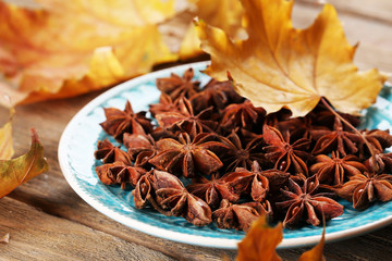 Stars anise on plate on wooden background