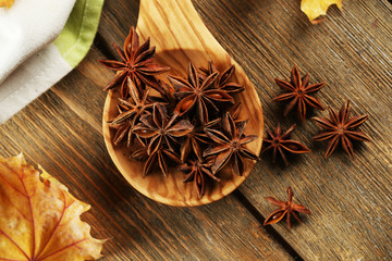 Stars anise in wooden spoon on table close up