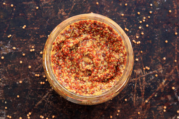 Traditional Dijon mustard on a brown rustic background