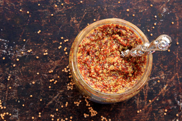 Traditional Dijon mustard on a brown rustic background