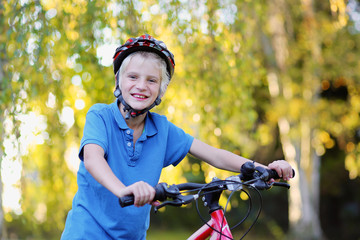 Naklejka premium Happy teenage boy riding with bike in the park