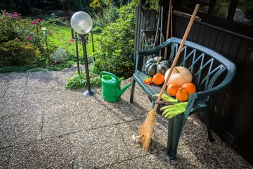 Terrasse im Oktober mit Gartenbank und Kürbissen