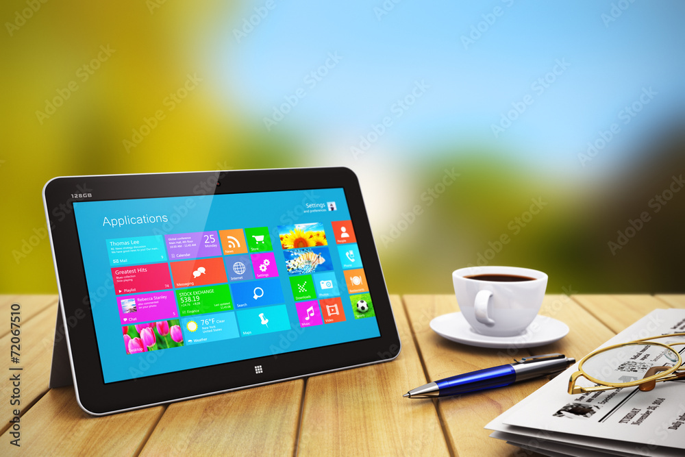 Poster tablet computer with business objects on wooden table outdoors