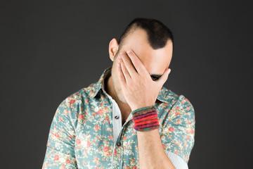 model isolated on plain background ashamed hiding face in hand