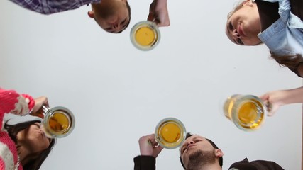 Happy friends clinking beer glasses. A bottom plan view.