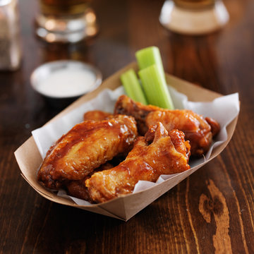 barbecue buffalo chicken wings with celery sticks and ranch sauce