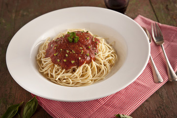 spaghetti dinner with tomatoes sauce and basil close up