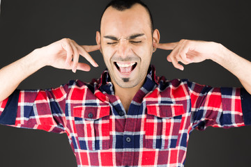 Naklejka premium model isolated on plain background plugging ears with fingers