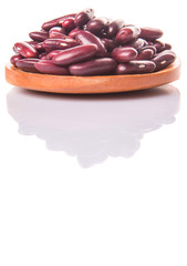 Red kidney beans on wooden spoon over white background