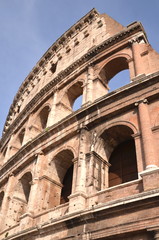 Monumentalne coloseum w Rzymie na tle niebieskiego nieba, Włochy - obrazy, fototapety, plakaty