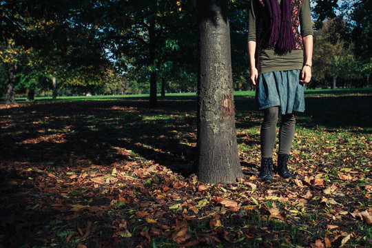 Young woman standing by a tree in autumn